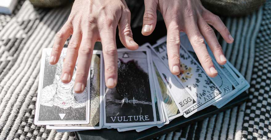 person cleansing tarot cards with hands
