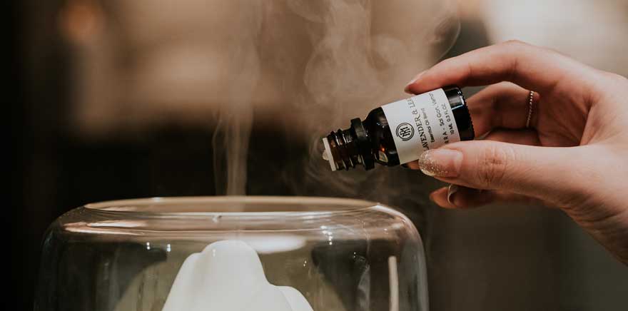 pouring drops of essential oils in a diffuser